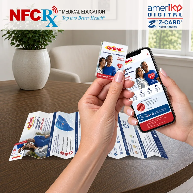A hand holding the ZCARD pocket booklet, opened flat, beside a phone showing the education spread it opens